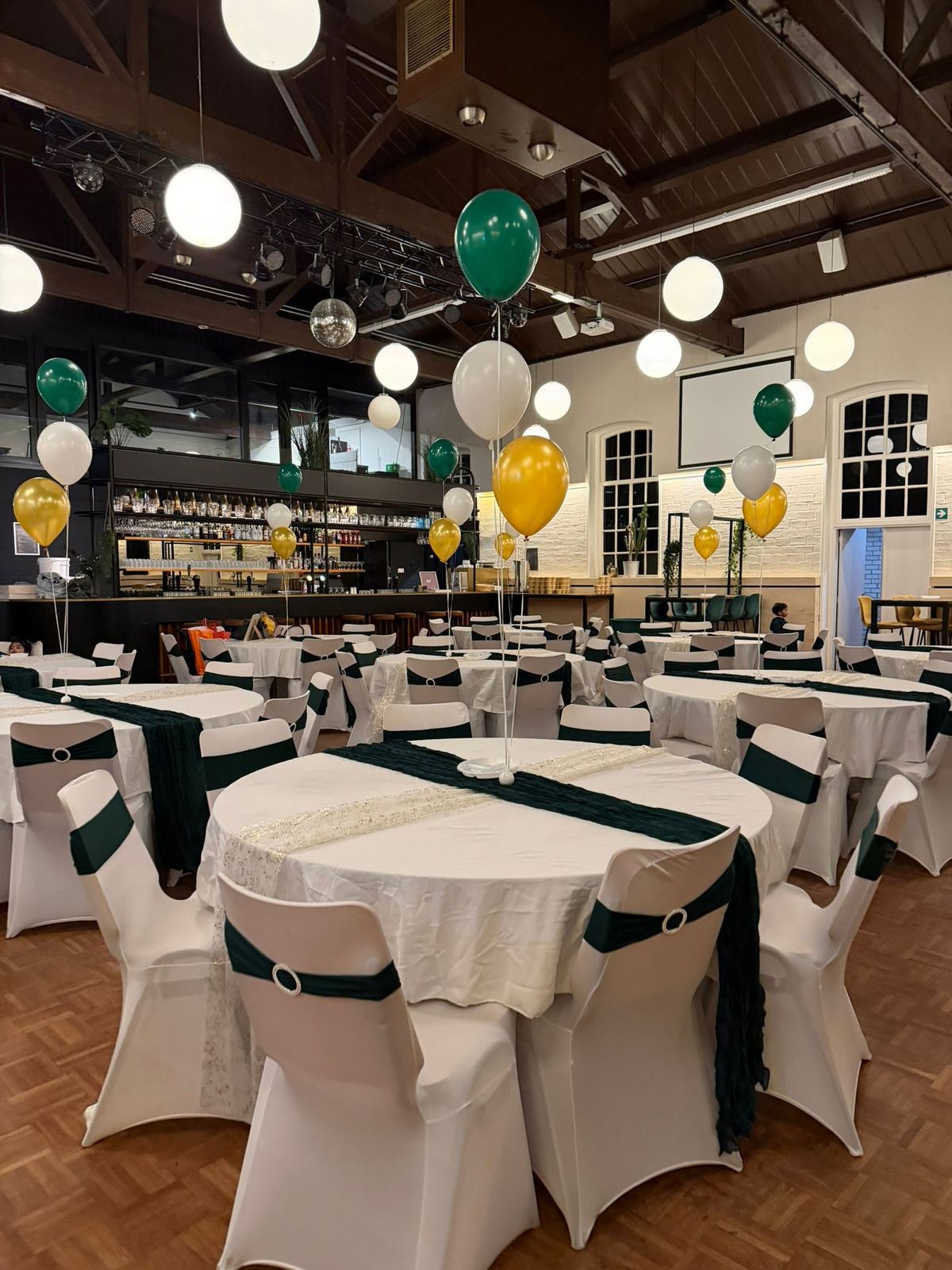 Feestzaal in groen en goud met ballondecoratie