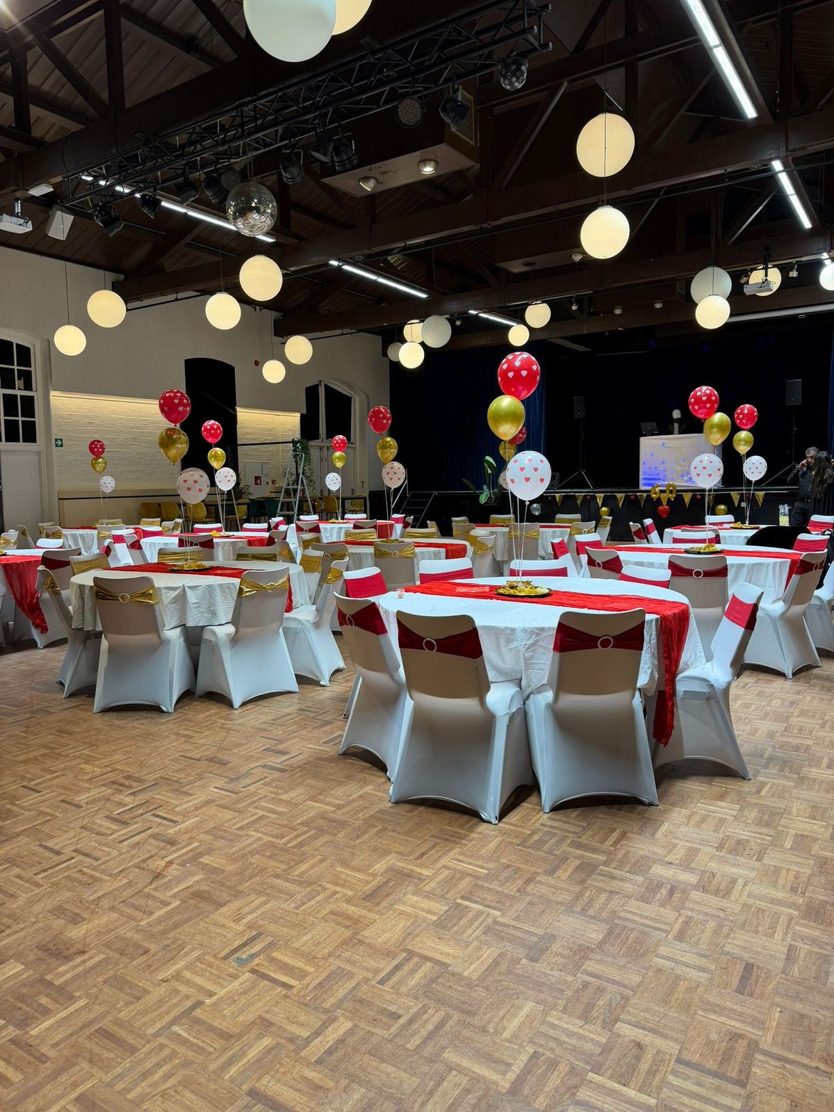 Feestzaal in rood en goud met hartjesballonnen